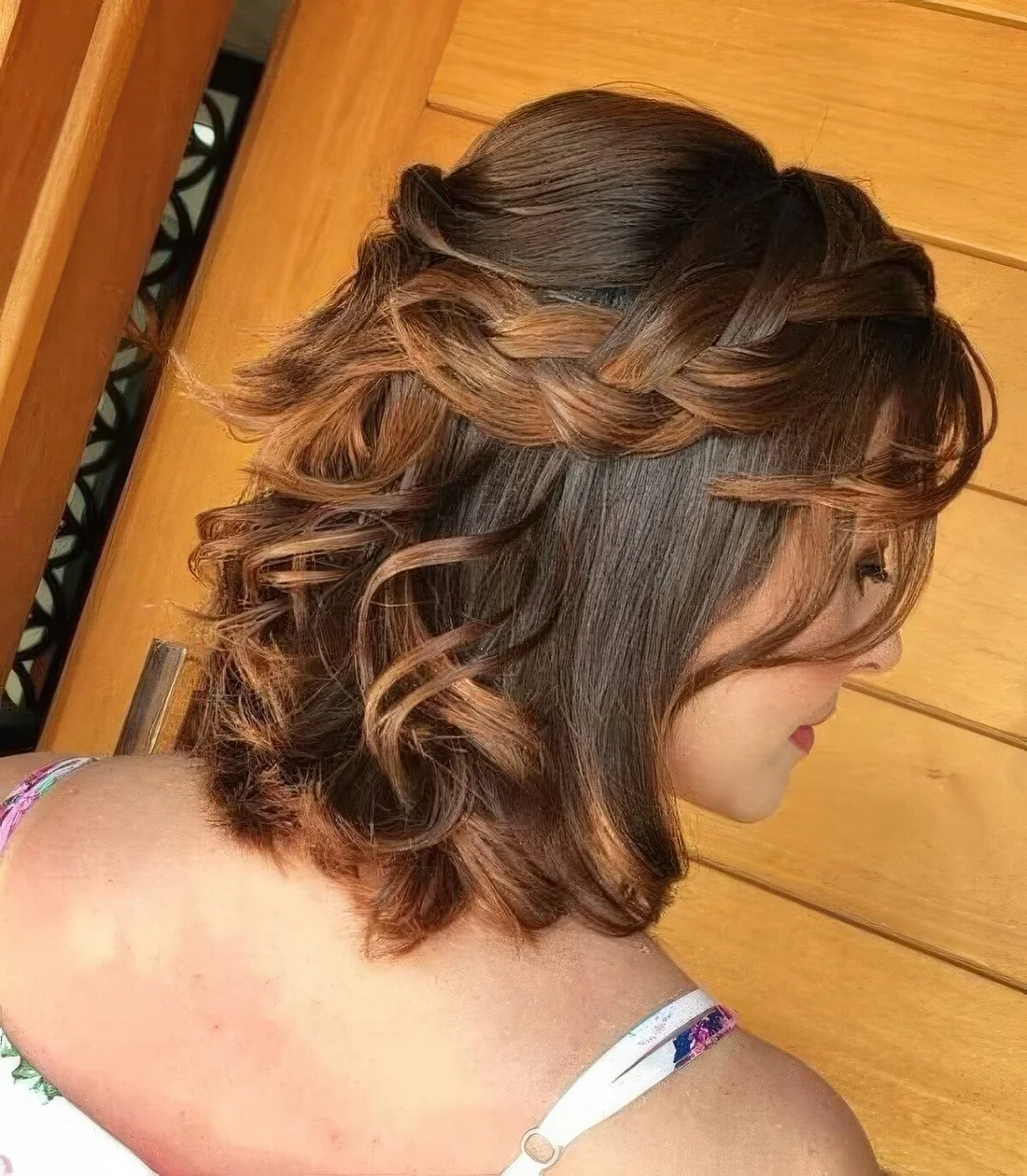 Half updo with a bump on top and a loose braided halo plus some waves down.
