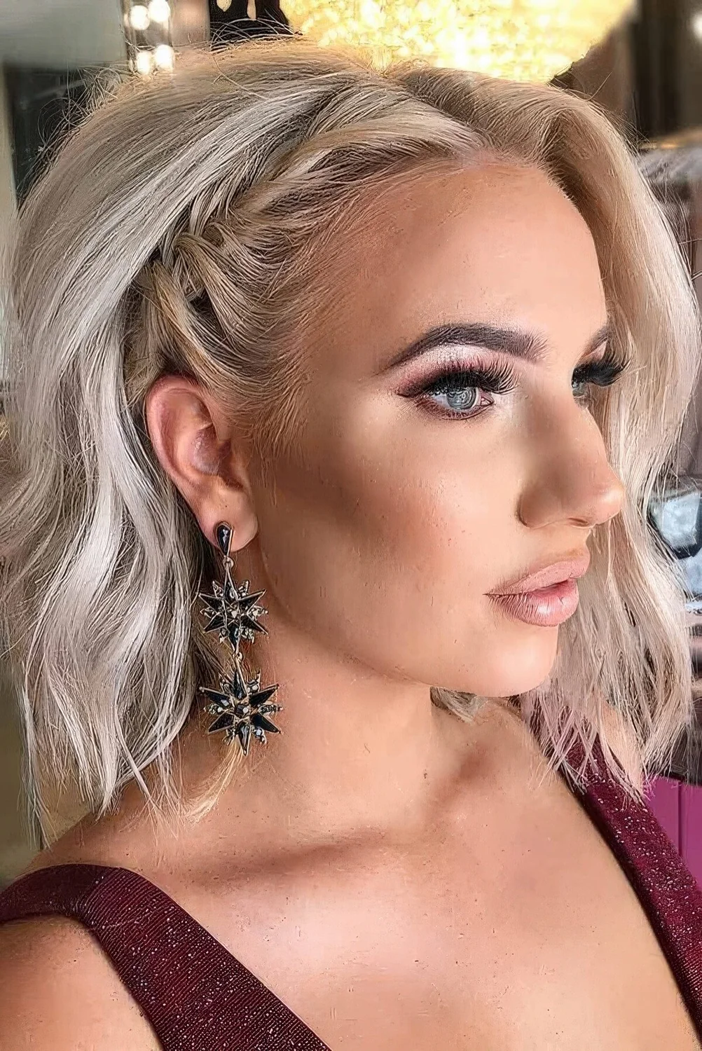 Long blonde bob with a side braid, volume and waves.