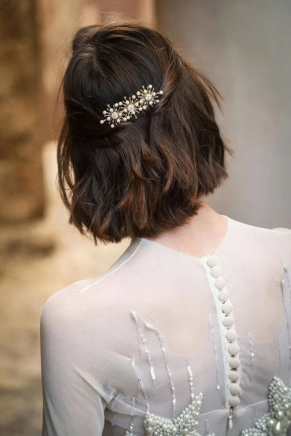 Long bob with wavy hair, styled as a half updo, with a beautiful rhinestona hair barrette.