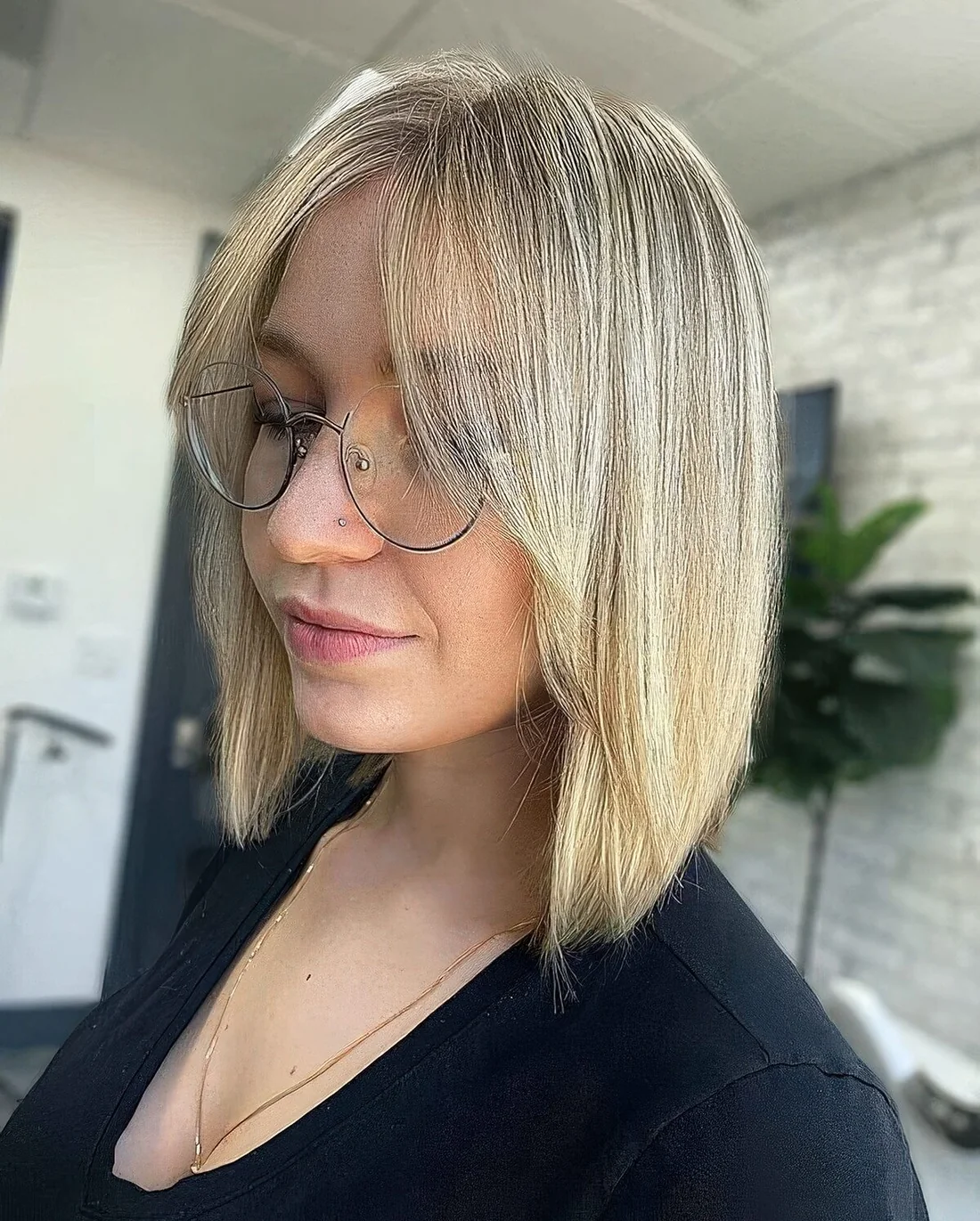 Blonde A line collarbone bob with curtain bangs.