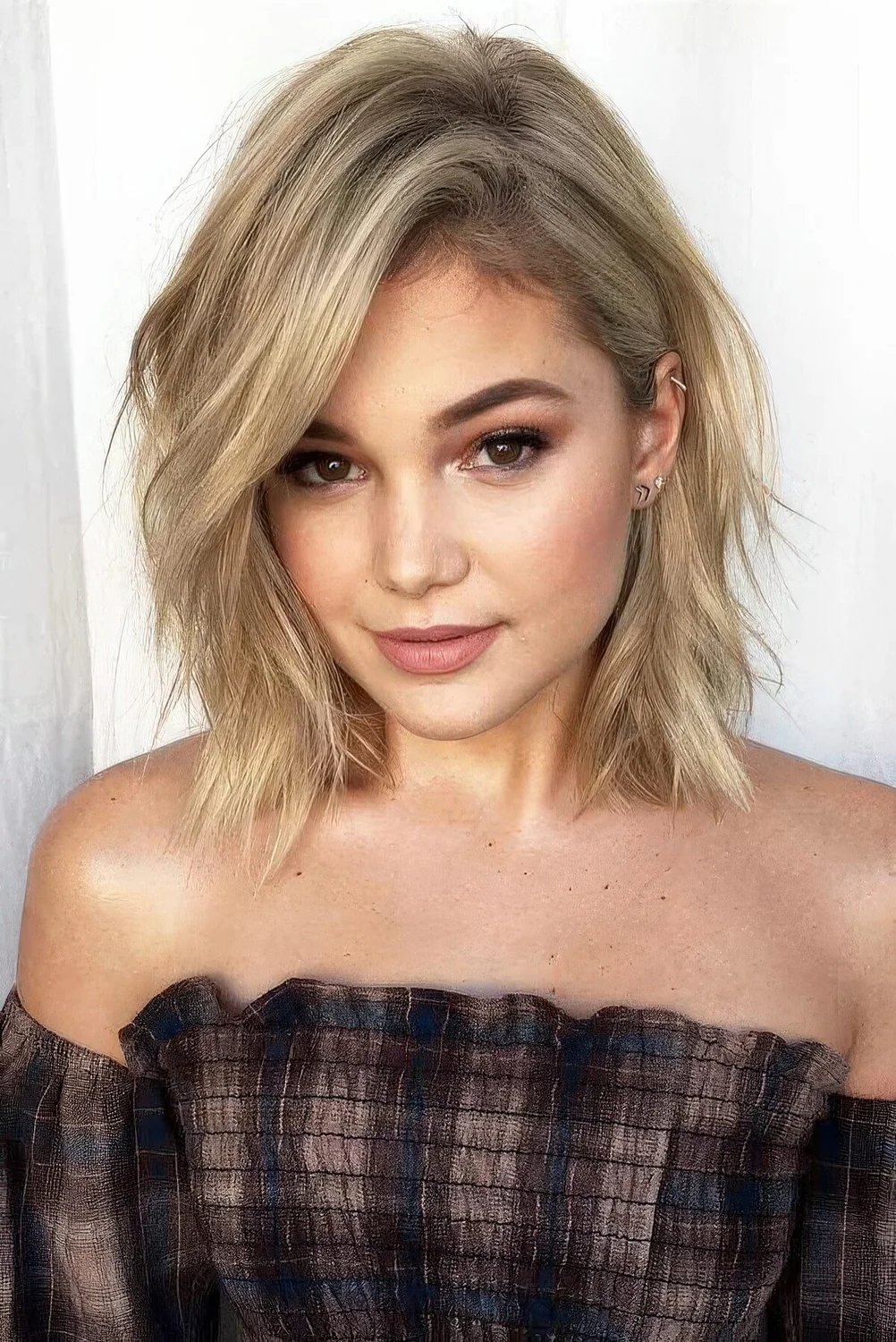 Blonde layered collarbone bob with a messy part and some waves.