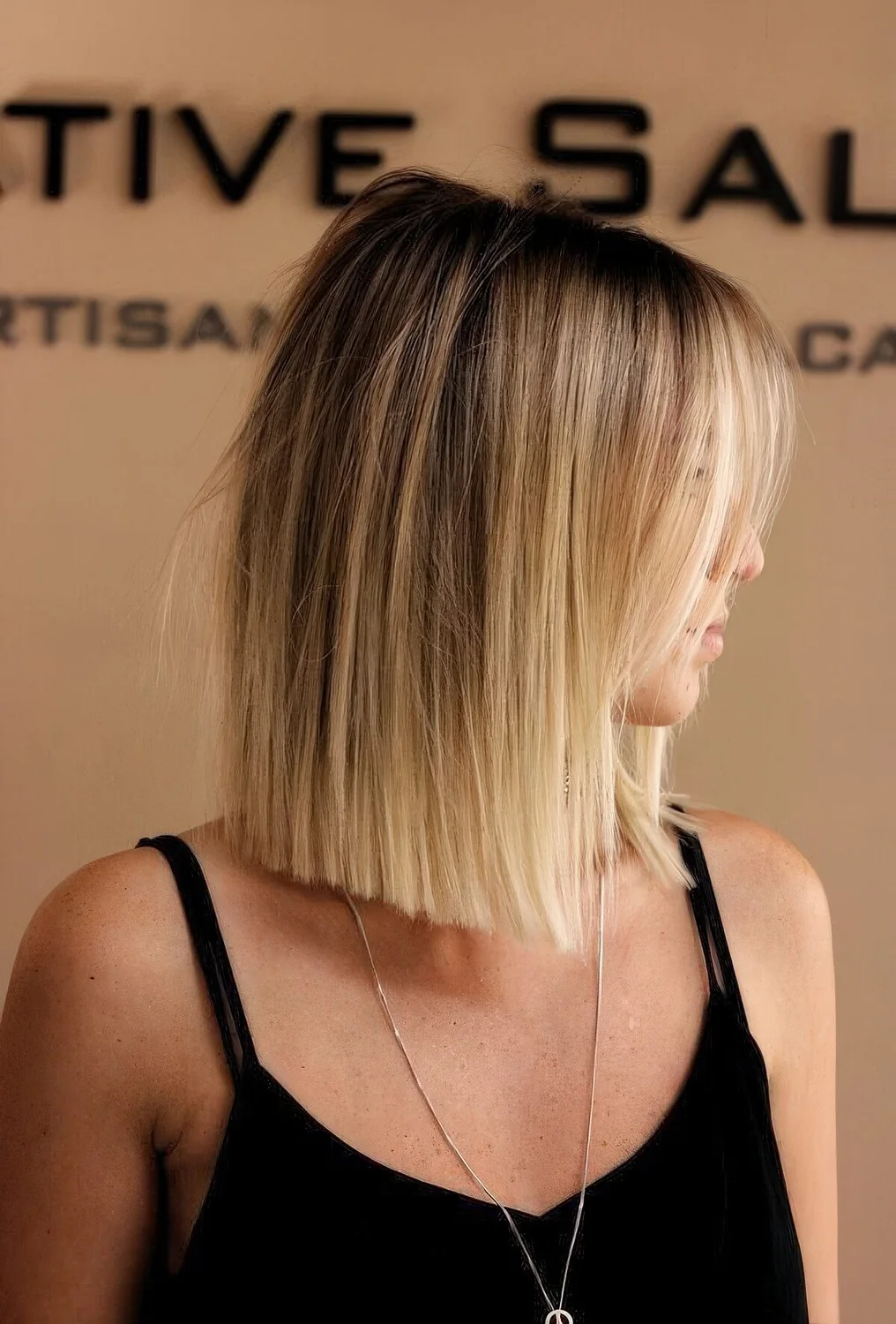 Effortless blonde collarbone bob with a darker root and blunt ends.