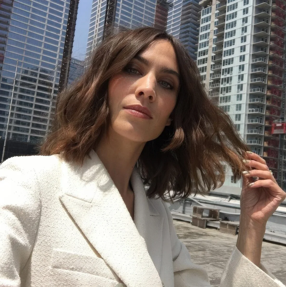 Alexa Chung rocking a brown wavy collarbone bob with center part.