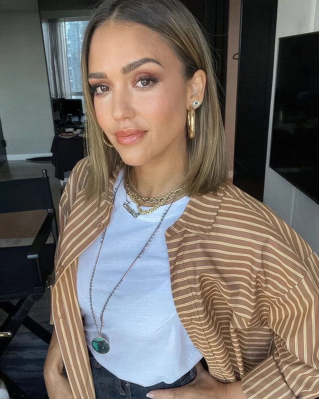 Jessica Alba rocking a mousy brown collarbone bob with blonde balayage and middle part.