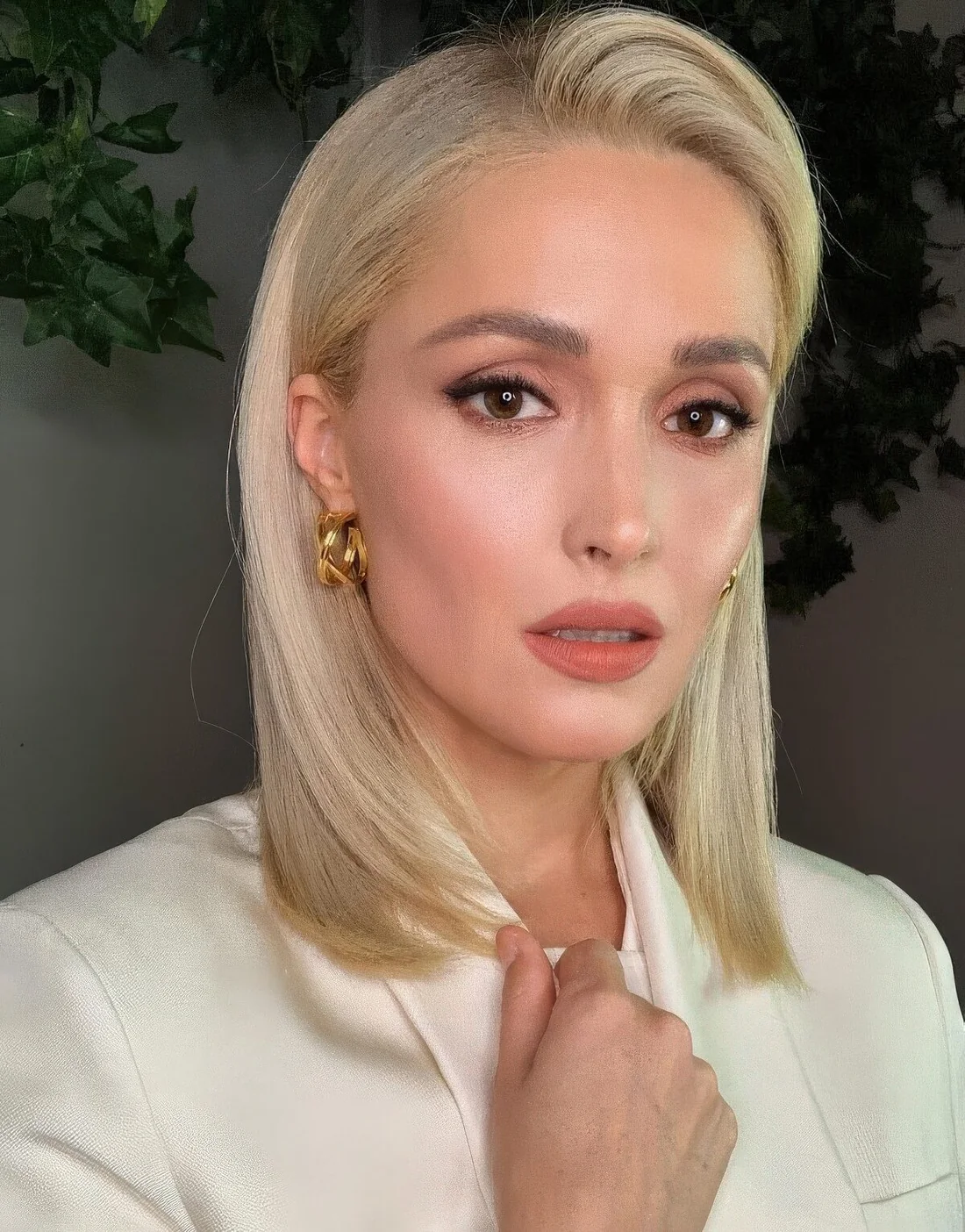 Rose Byrne wearing a blonde collarbone bob with side part and a bit of volume on top plus straight and sleek hair.