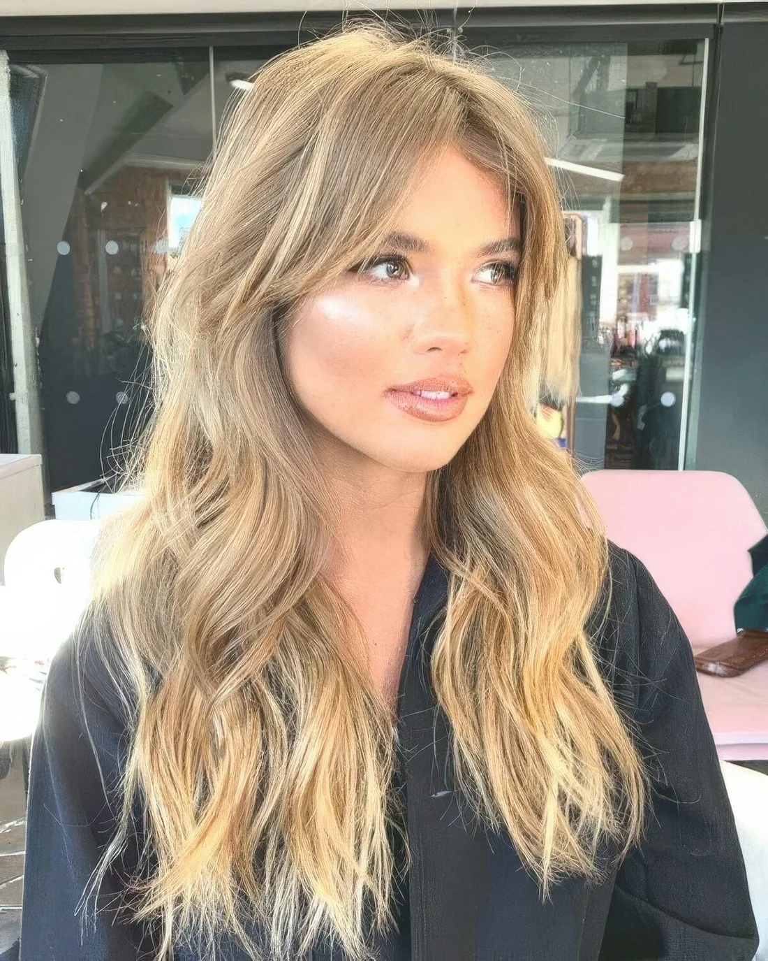 Blonde balayage with curtain bangs and long waves down.