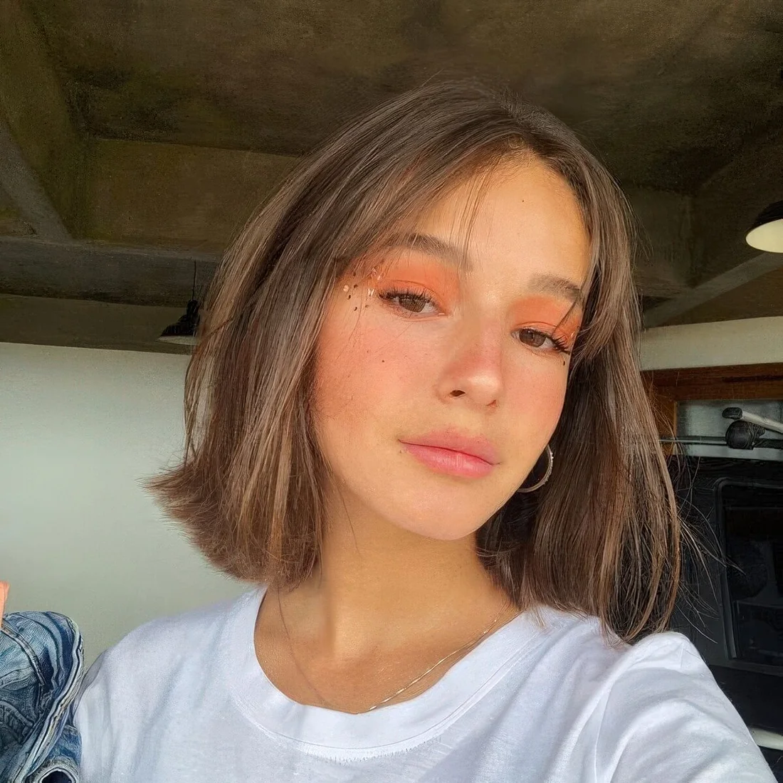 Brunette long bob with curtain bangs.