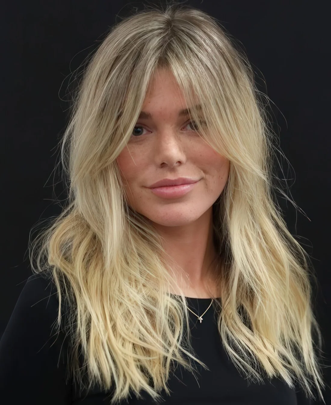 Long blonde hair with curtain bangs and much texture.