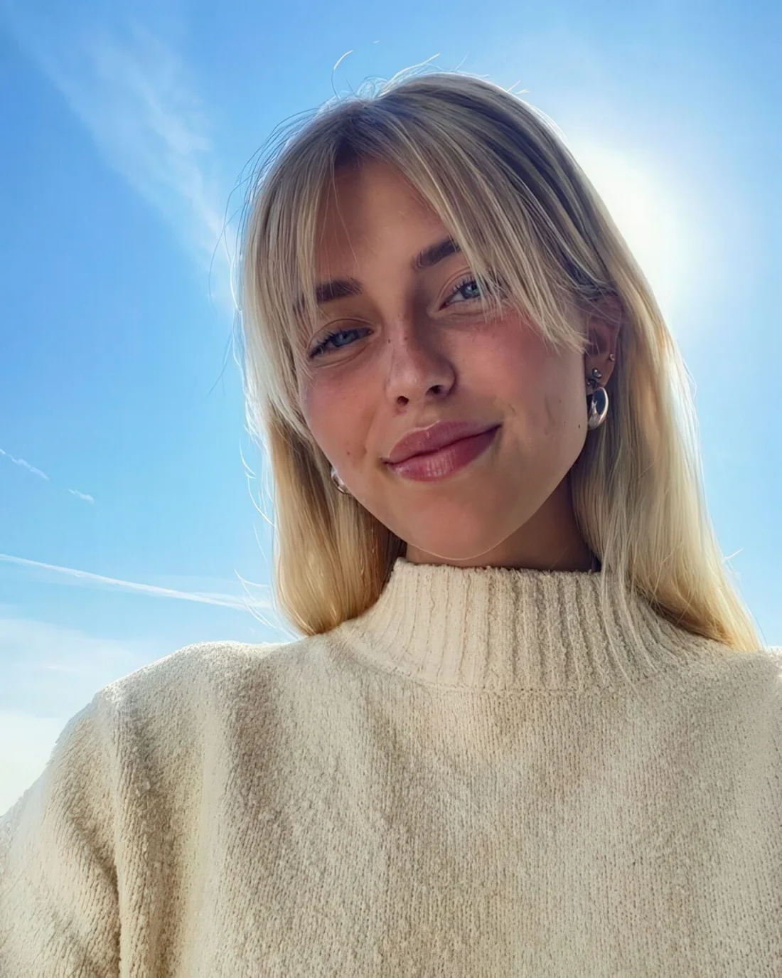 Long blonde hair paired with curtain bangs.