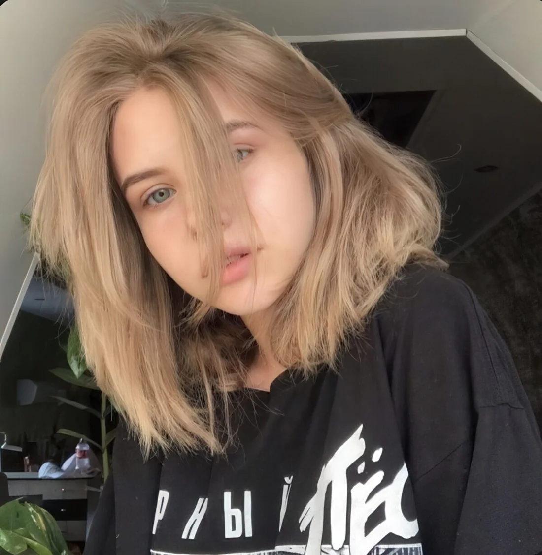Blonde medium-length hair with long curtain bangs.