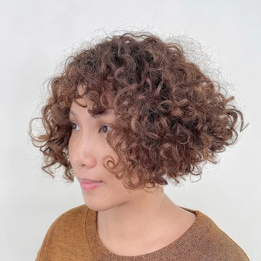 Curly inverted bob with short bangs.