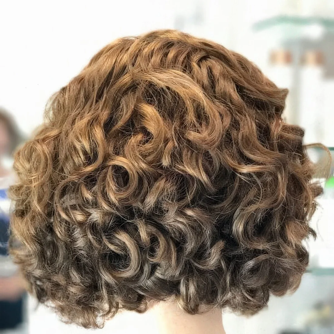 Curly light brunette asymmetrical bob.