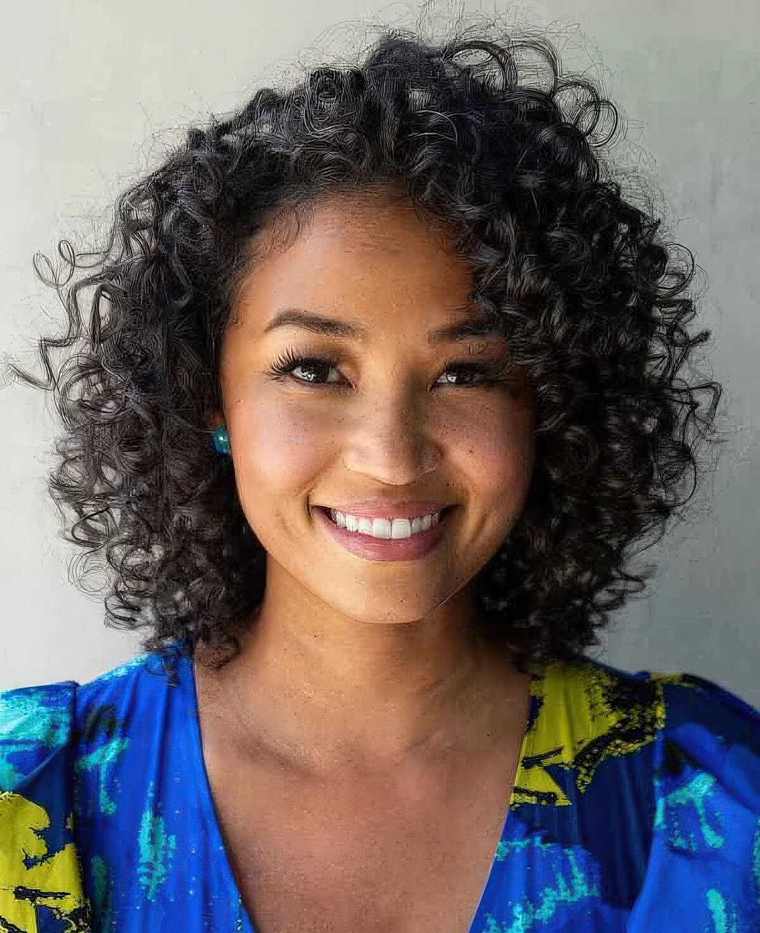 Naturally curly bob haircut with loose curls and shine.