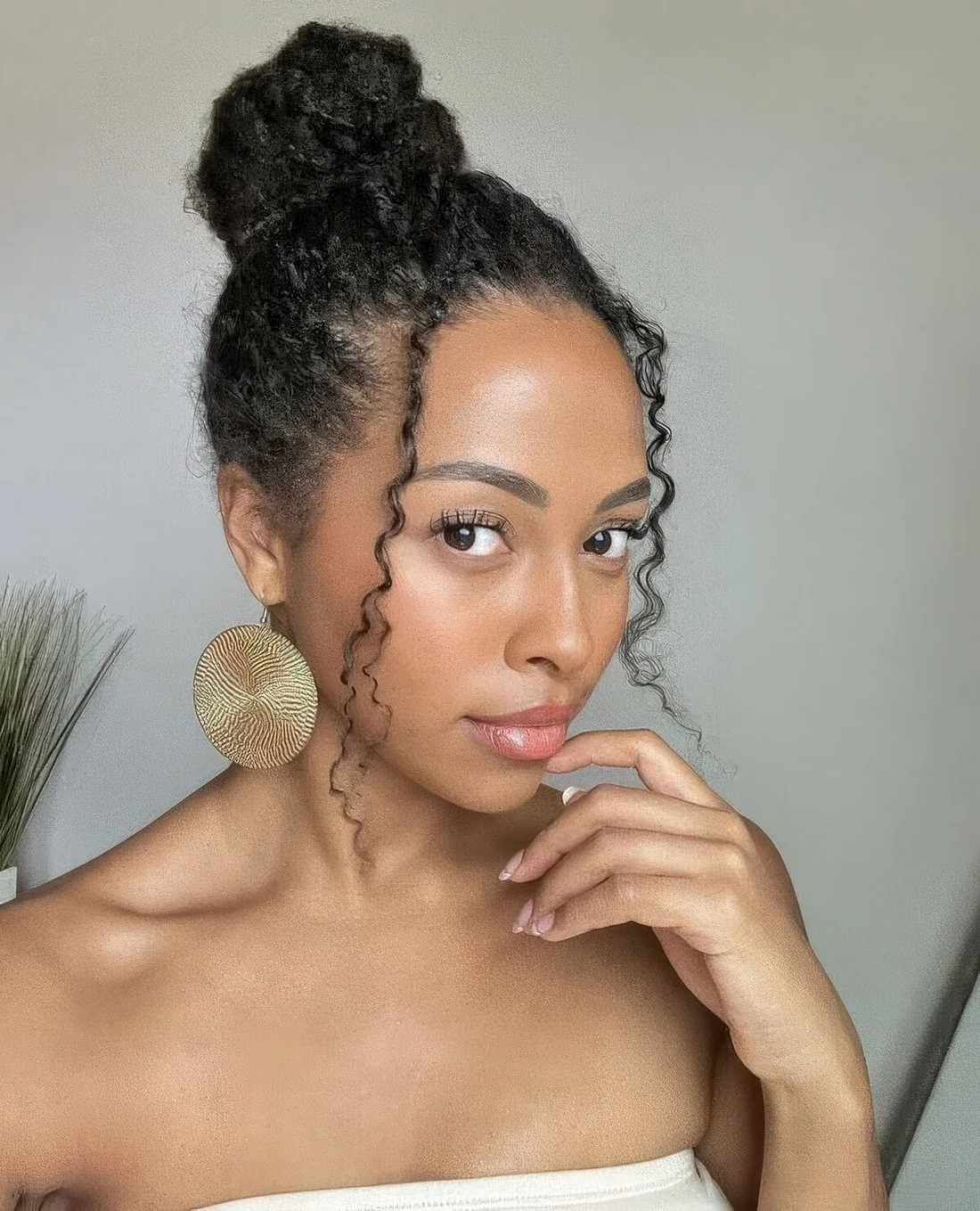 Photo showing top knot with curls, with the hairstyle clearly visible.
