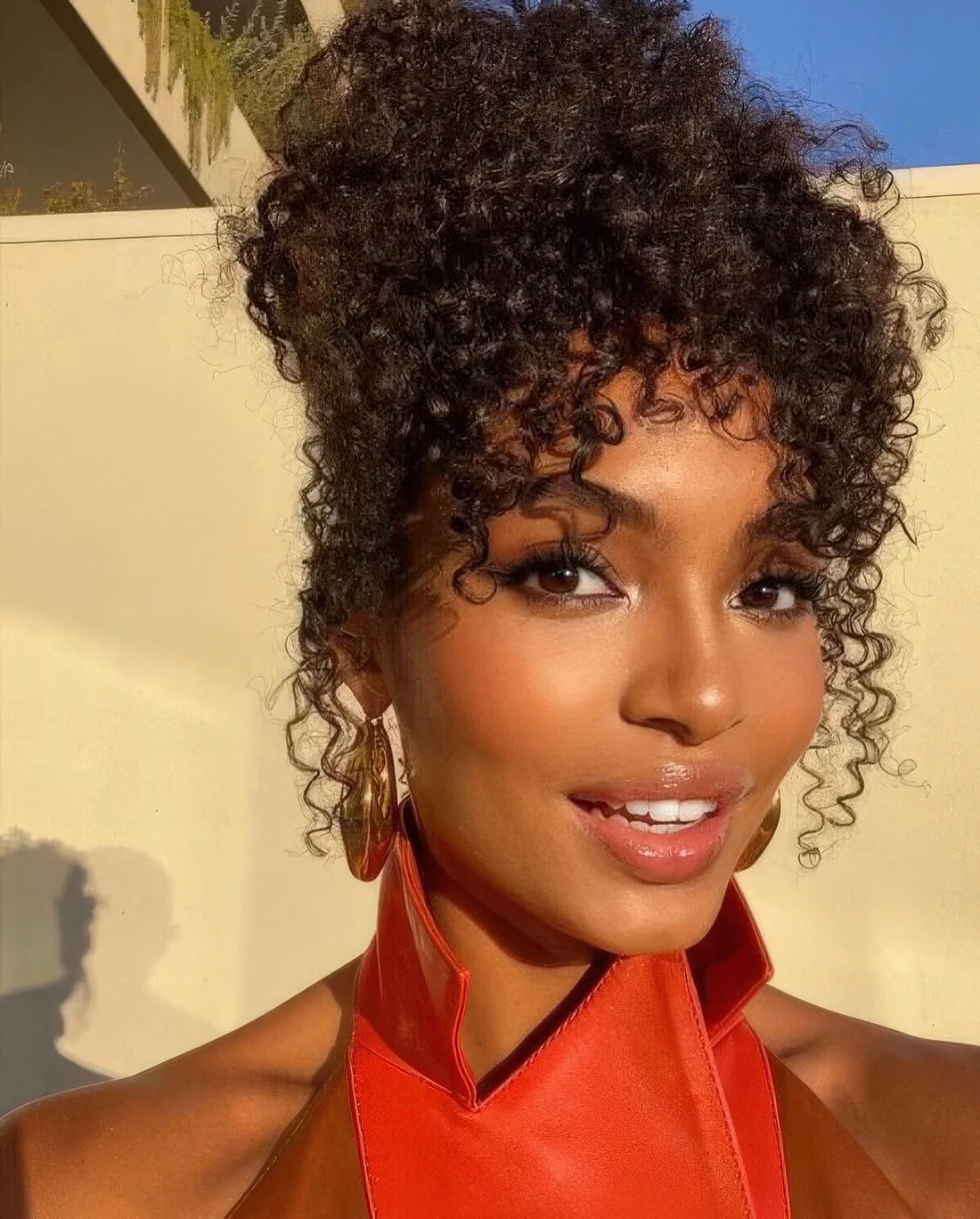 Curly updo with curls framing and face and accenting the eyes.