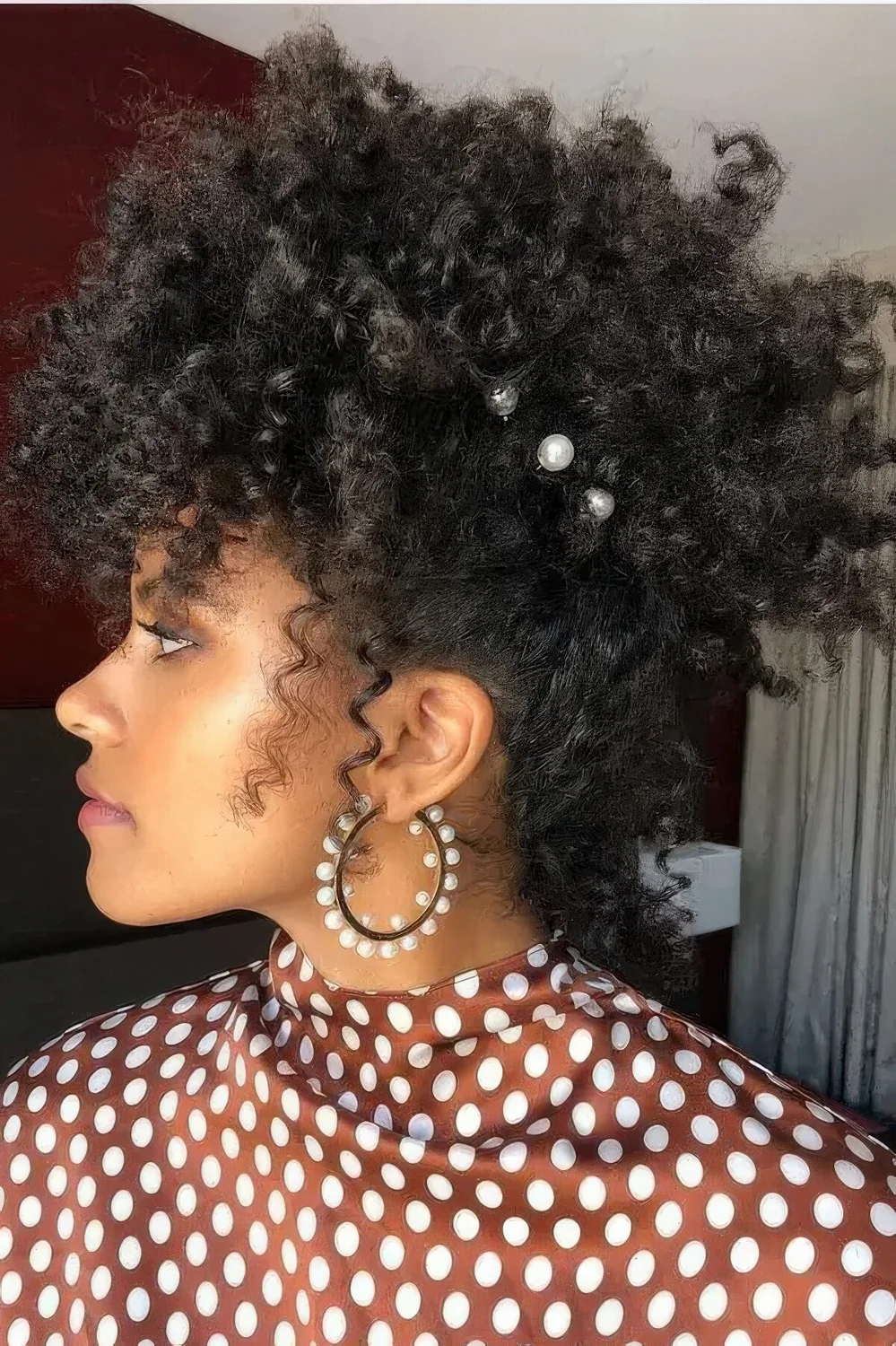 Curly updo with pearl hair pins and some locks down to frame the face.