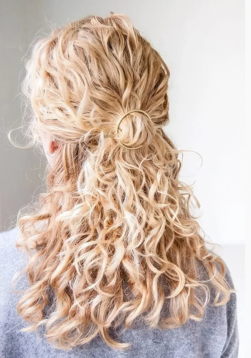 Romantic and easy to make curly half updo with a ring hairpiece and curls down.