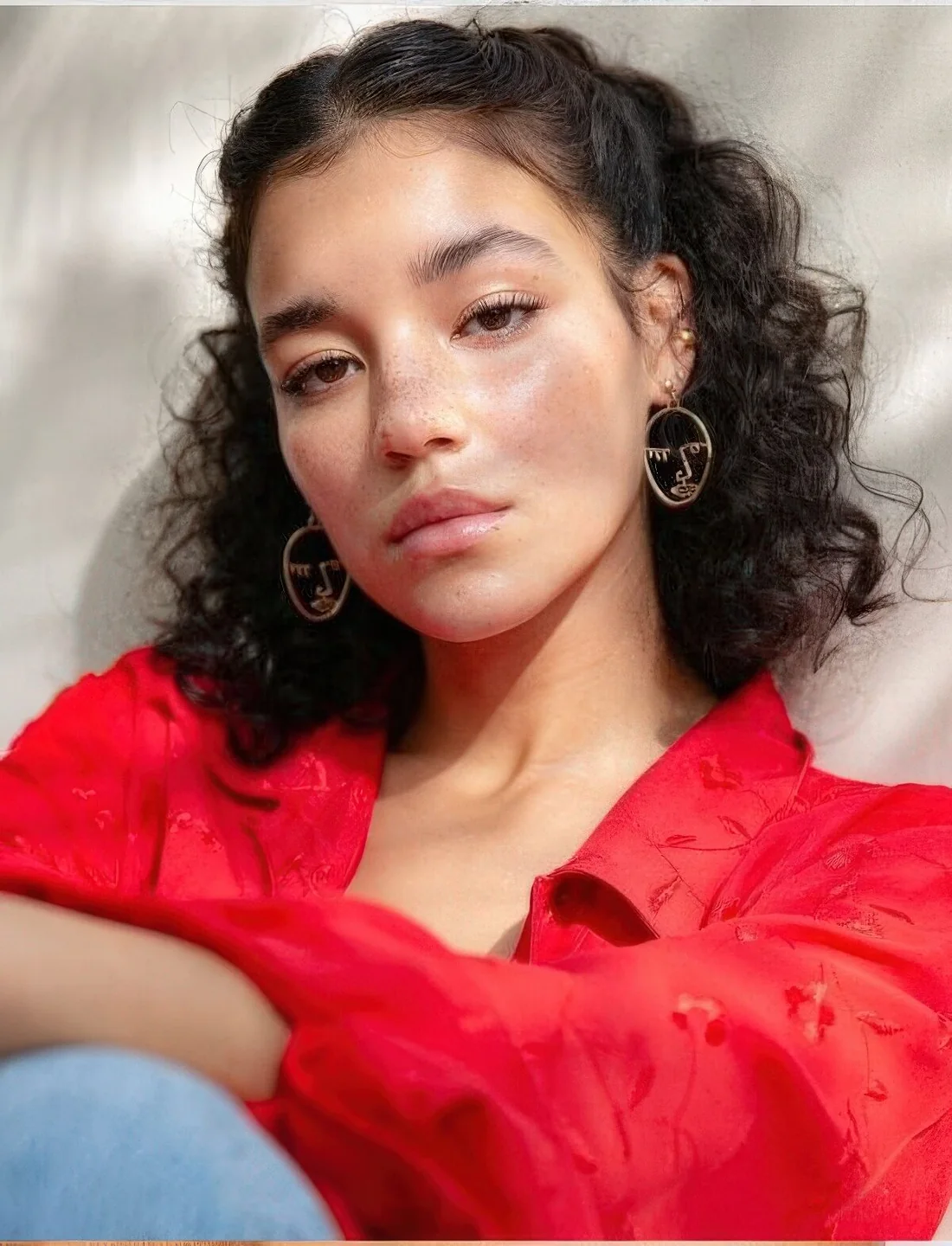 Curly medium-length hair styled as a half updo, with a volume on top.