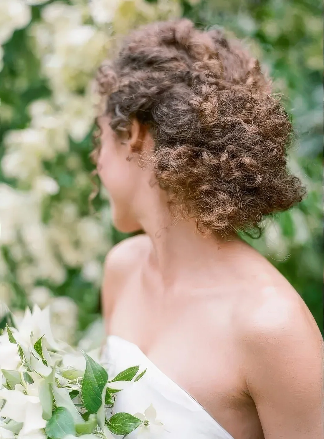 Braided low updo with natural curls.