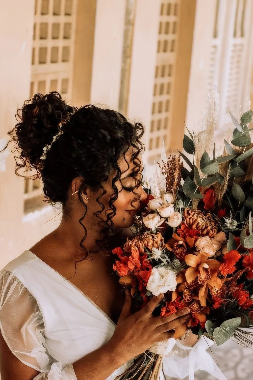 Curly top knot with some curls down and a rhinestone hair vine around the knot.