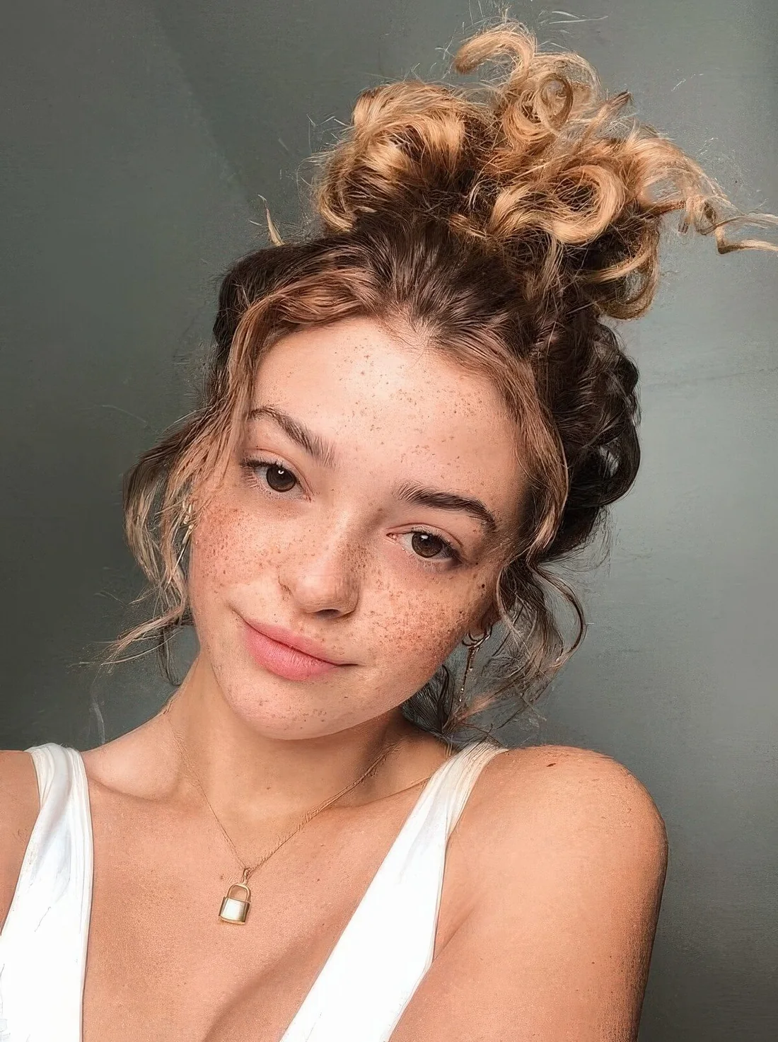Curly top knot with some curls framing the face.