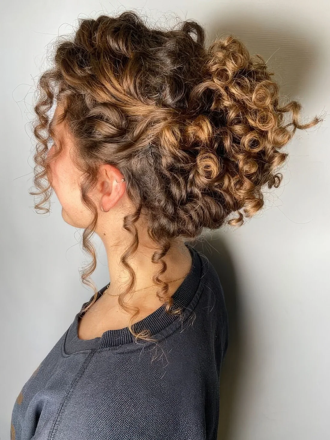 Curly updo with a curly top and some curls down to make it look more effortless.