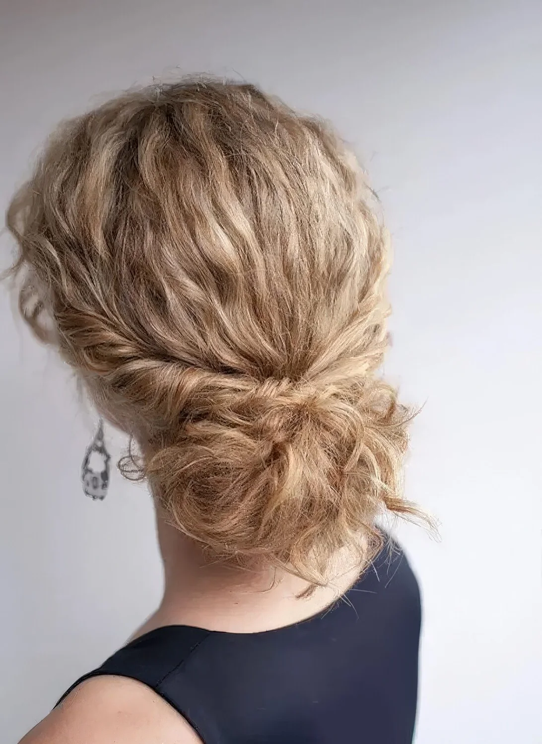 Low bun with straightened hair and locks down.