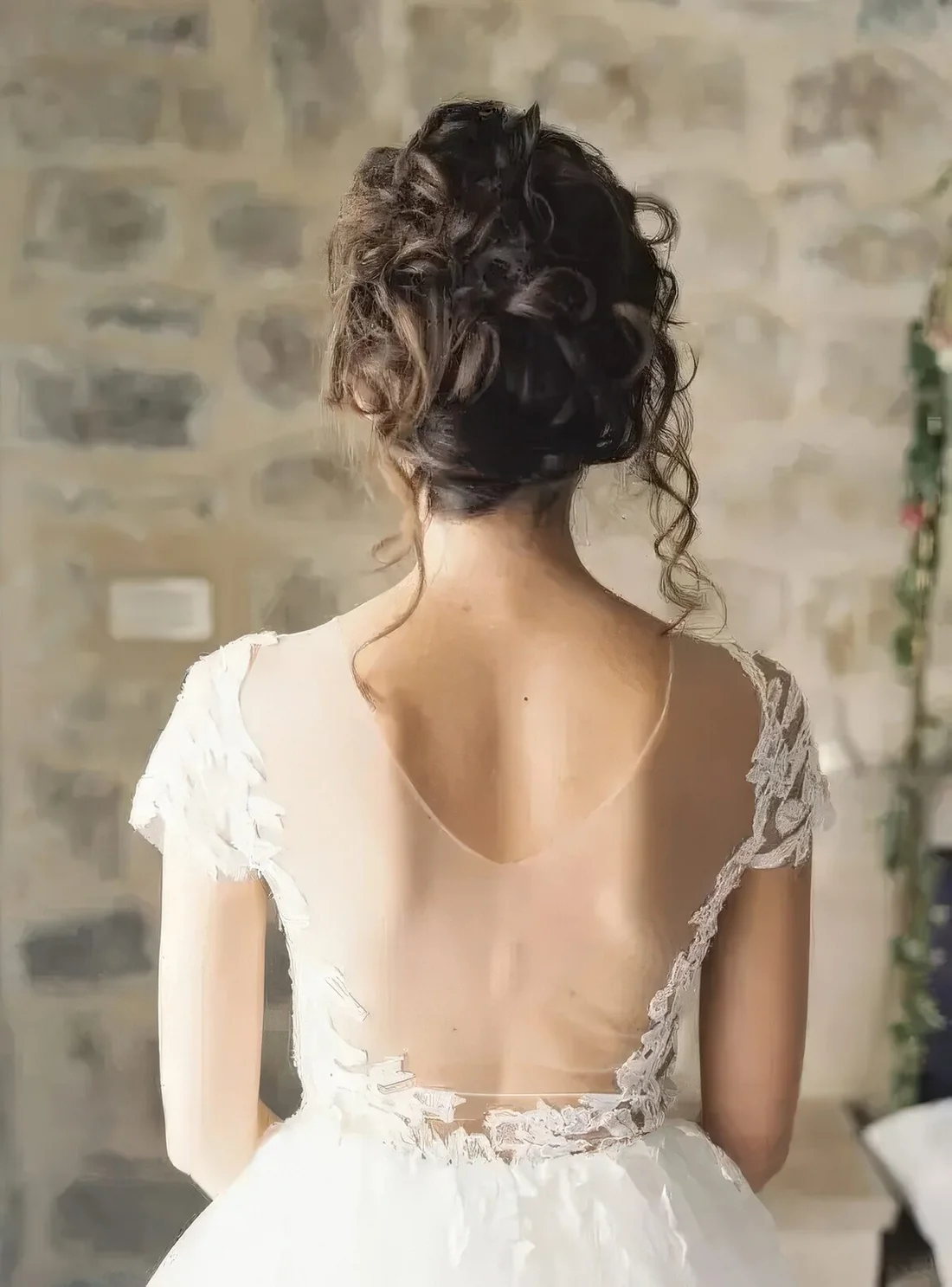 Photo showing messy curly wedding updo, with the hairstyle clearly visible.
