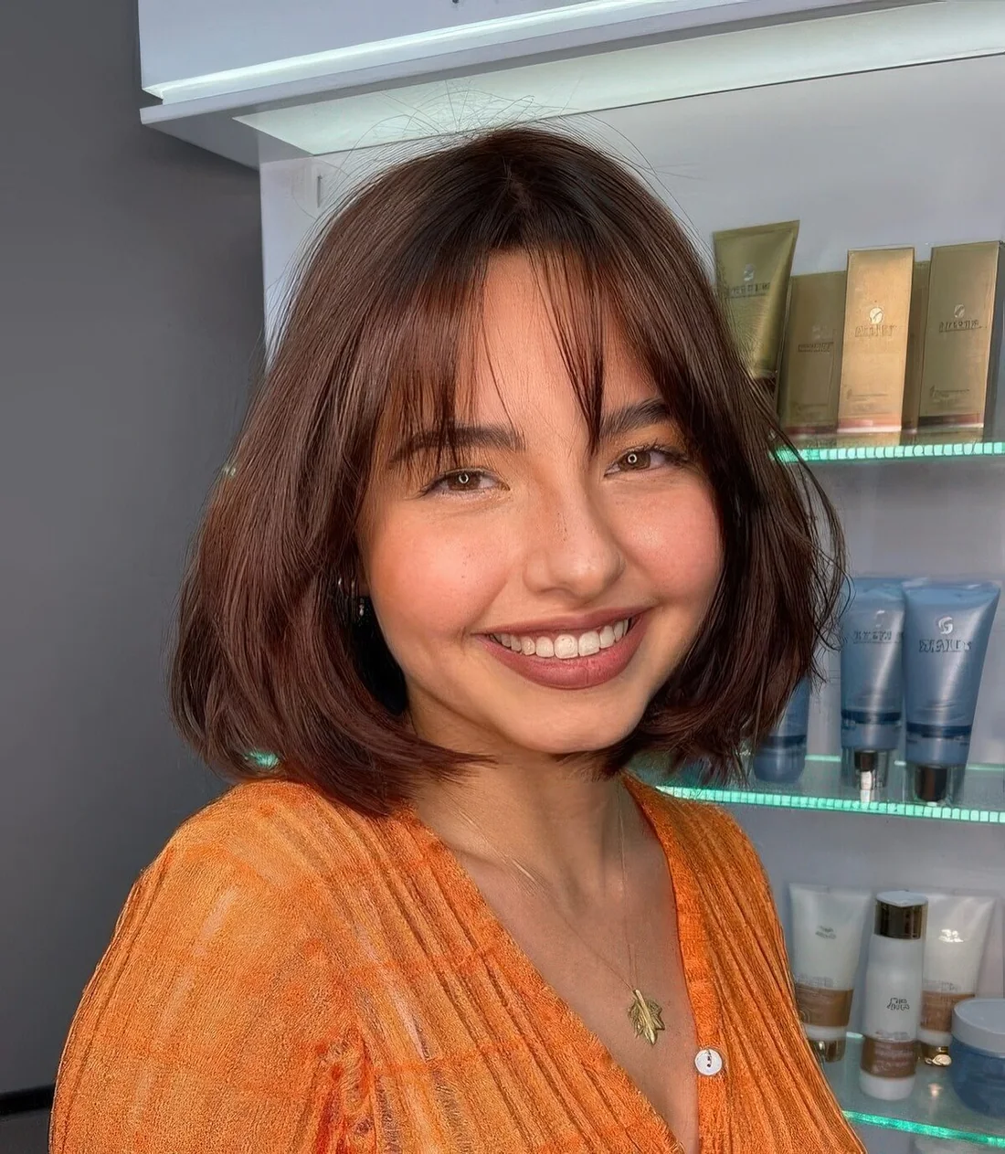 Burgundy rounded bob with wispy bangs.