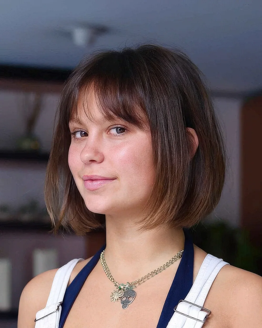 Dark brown chin-length bob with a slight ombre effect and wispy bangs.