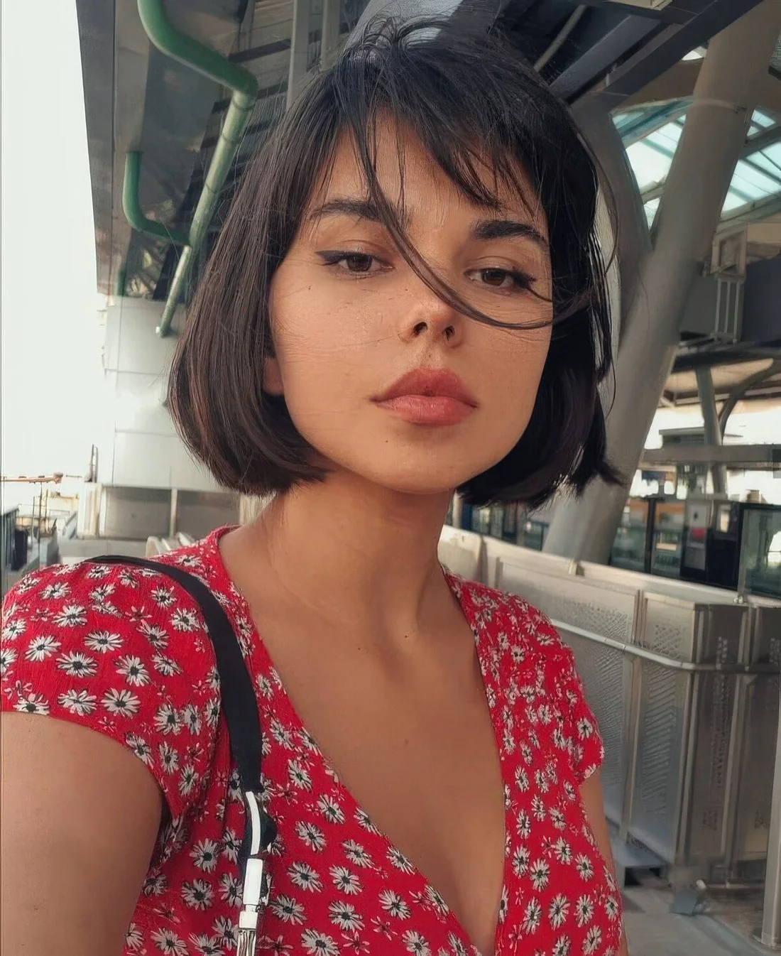 Dark brown chin-length bob with wispy bangs.