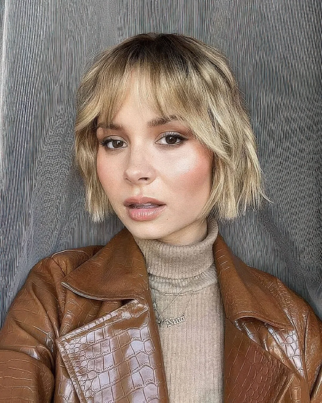 Relaxed blonde wavy jaw ling bob with wispy bangs.