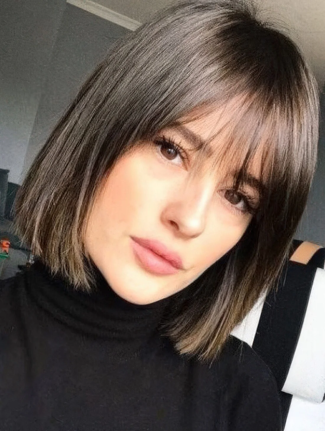 Dark brown short bob with wispy bangs.