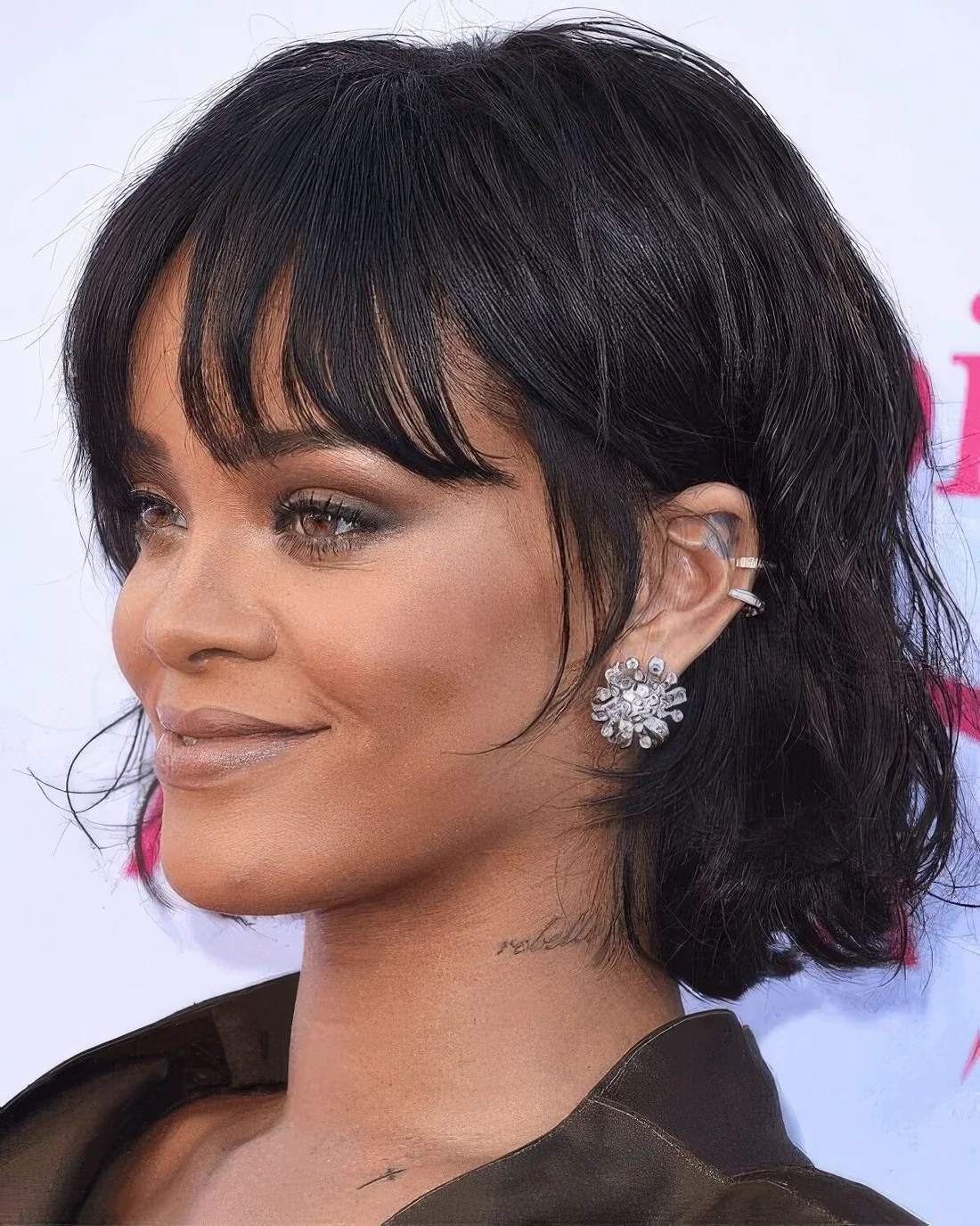 Rihanna rocking a black chin-length bob with messy waves and wispy bottleneck bangs.