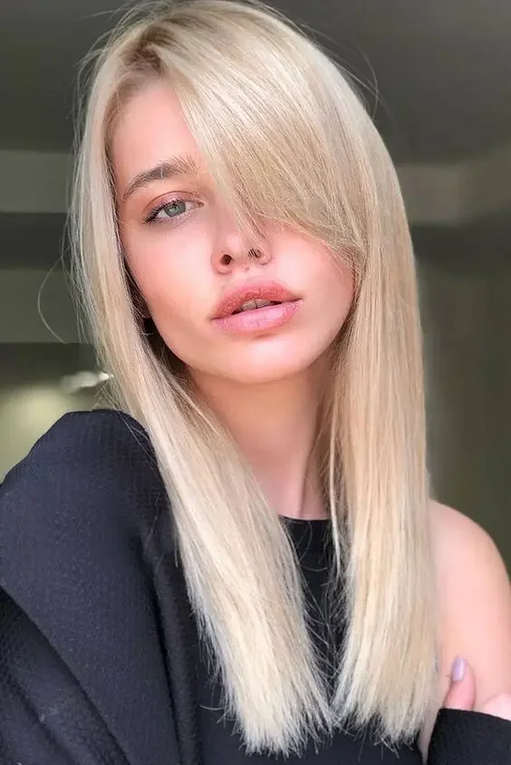 Long delicately blonde sleek hair with side bangs.