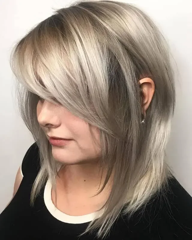 Silver blonde medium-length hair with straight side bangs and highlights.