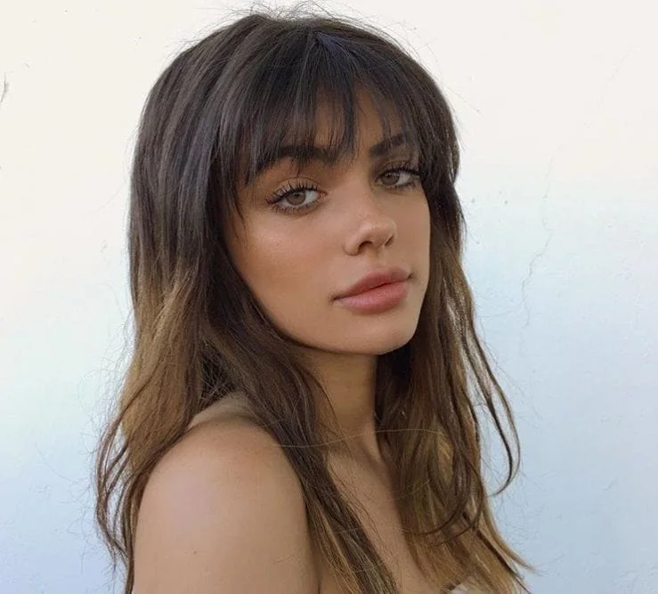 Chocolate caramel ombre hairstyle with wispy bangs.