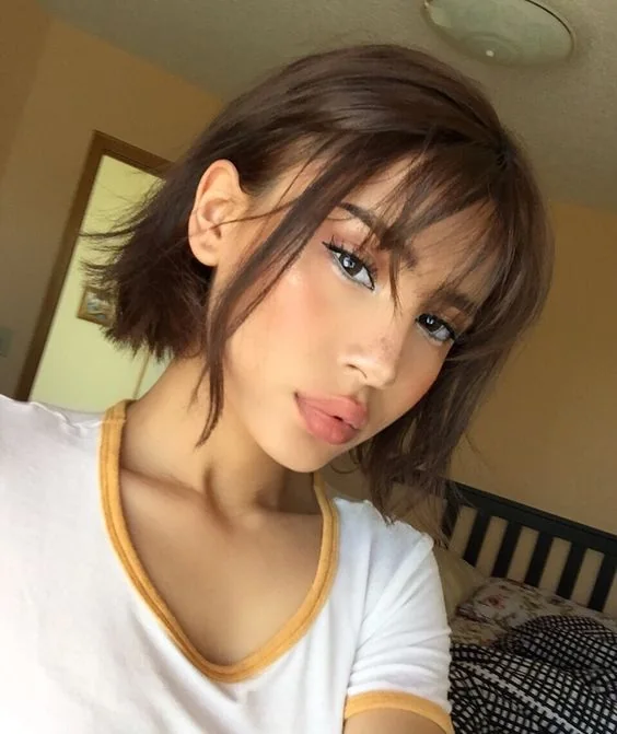 Photo showing short brown bob with wispy bangs, with the hairstyle clearly visible.