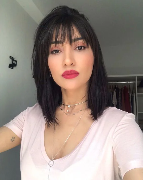 Black meidum length hair with delicate wispy bangs for a cuter and more girlish touch.