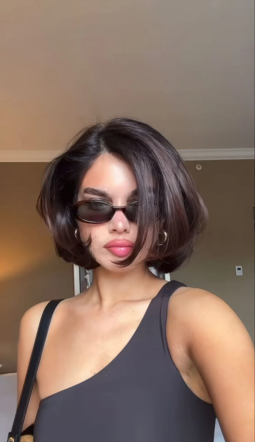 Chocolate brown chin-length volumetric bob with curled ends.