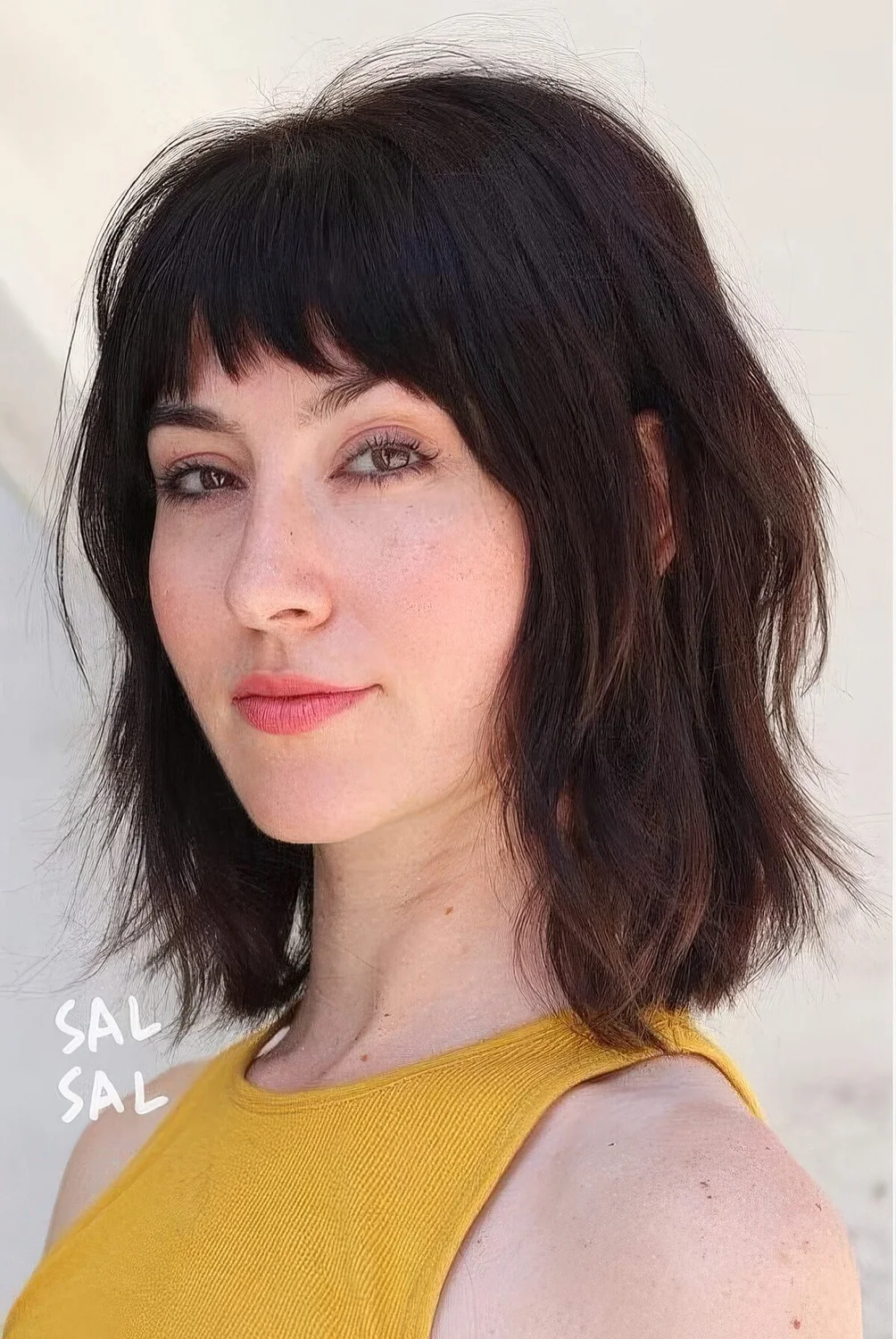 Dark brown long bob with a usual fringe and a shaggy texture.