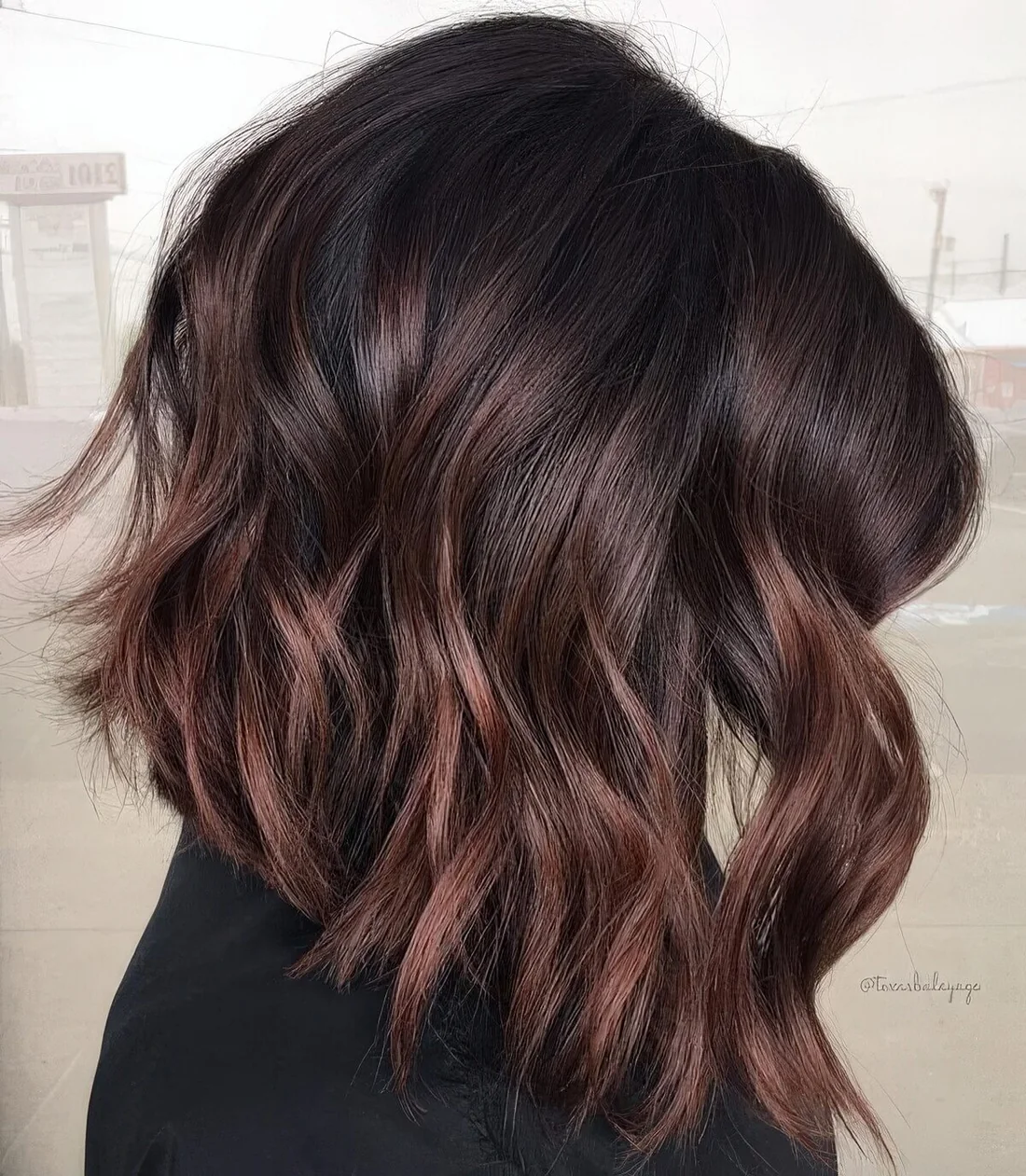 Dark brown long bob with copper balayage, waves and volume.