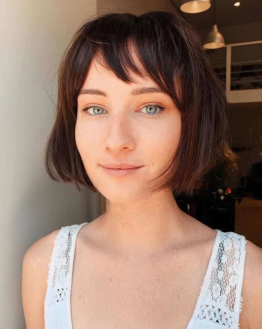 Dark brunette chin-length bob with wispy bangs.