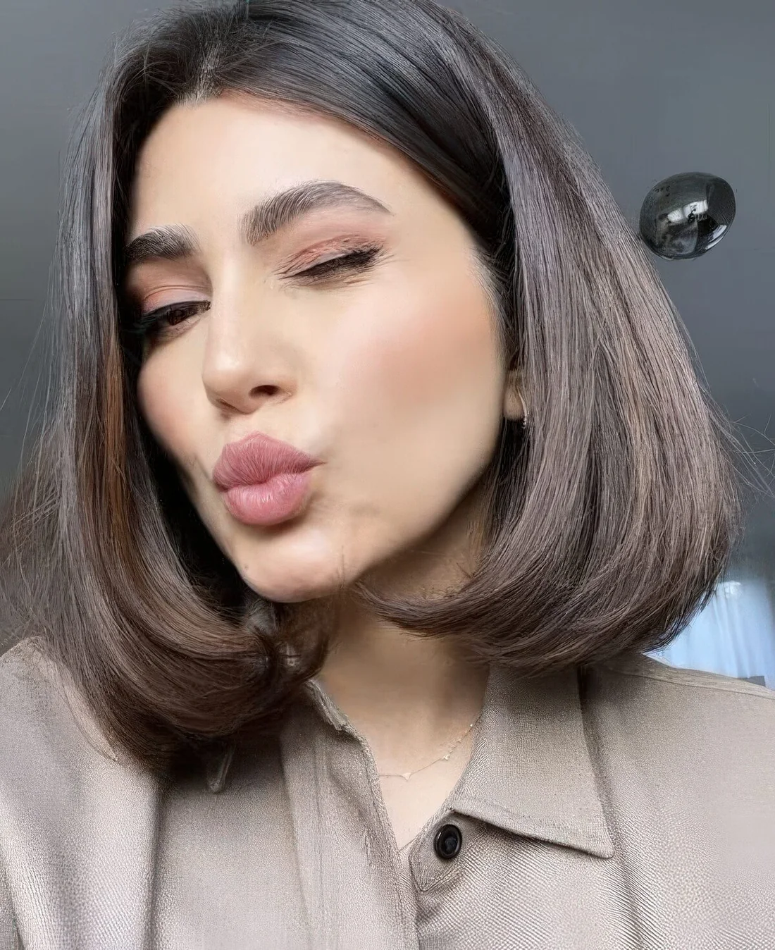 Deep brown liquid bob with center part and much volume.