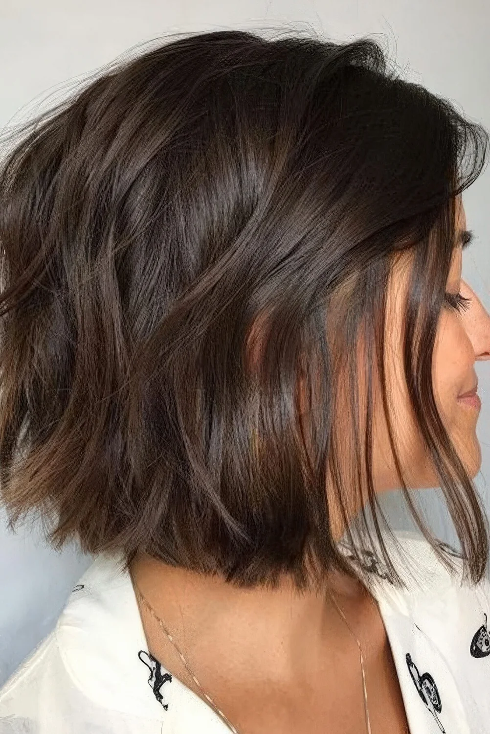 Chocolate brown mid bob with a lot of volume and some wavy texture.