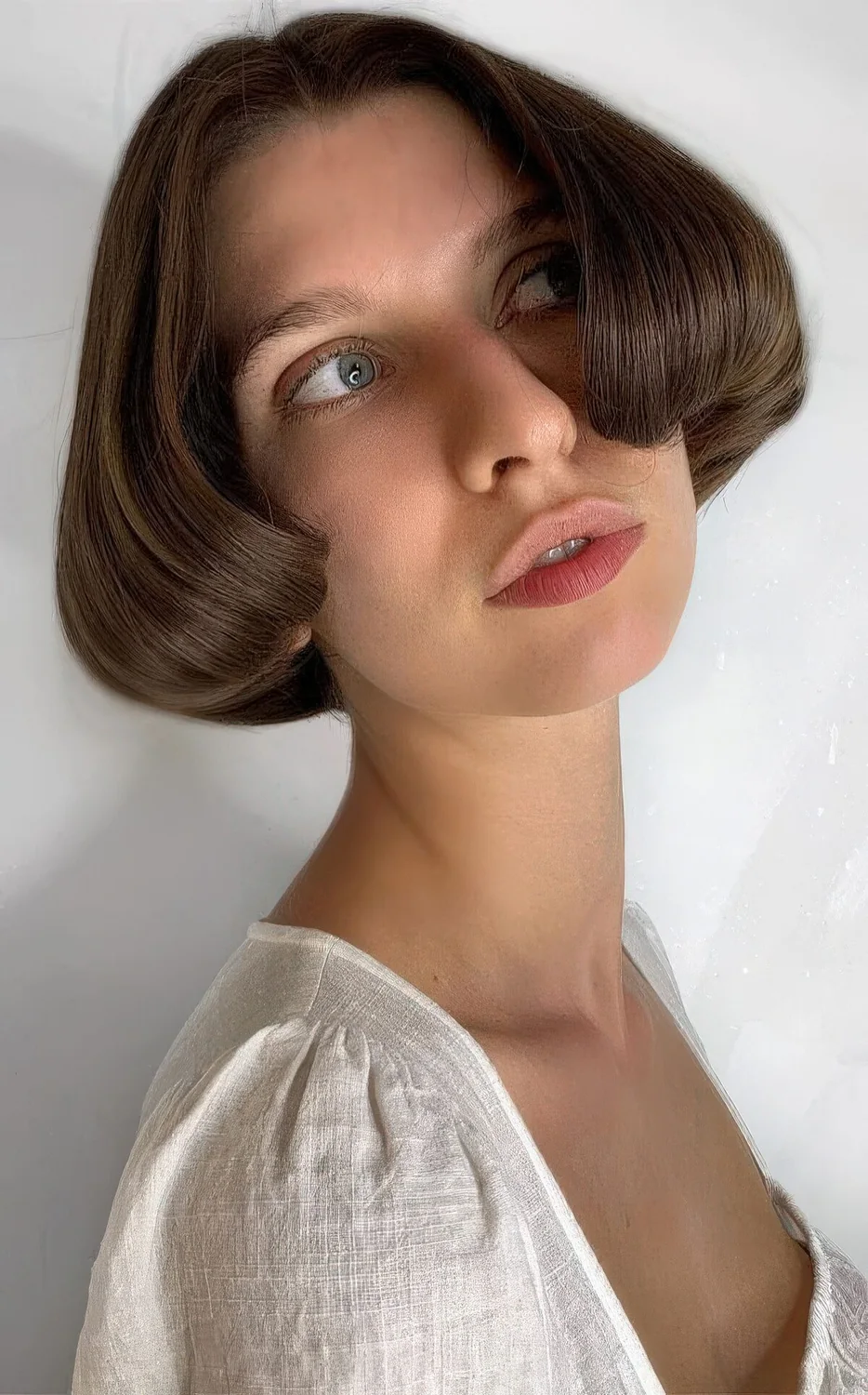 Ear-length bob with center part and curved ends.