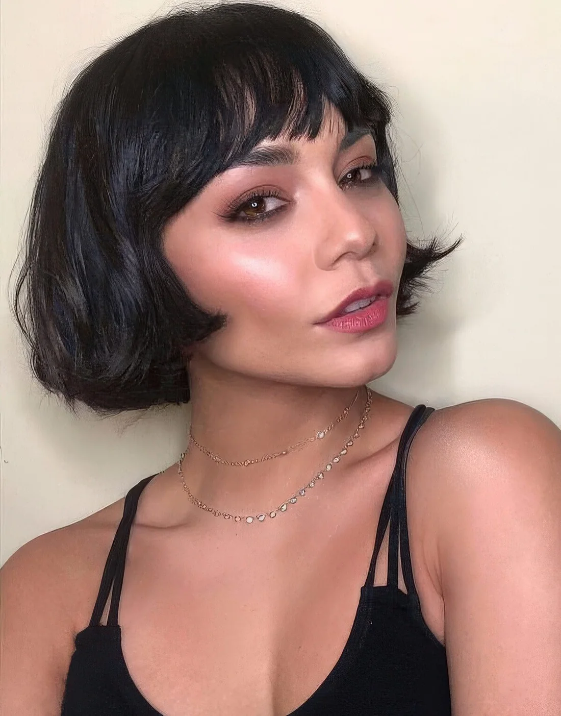 Black ear-length bob with wispy bangs and wavy hair.