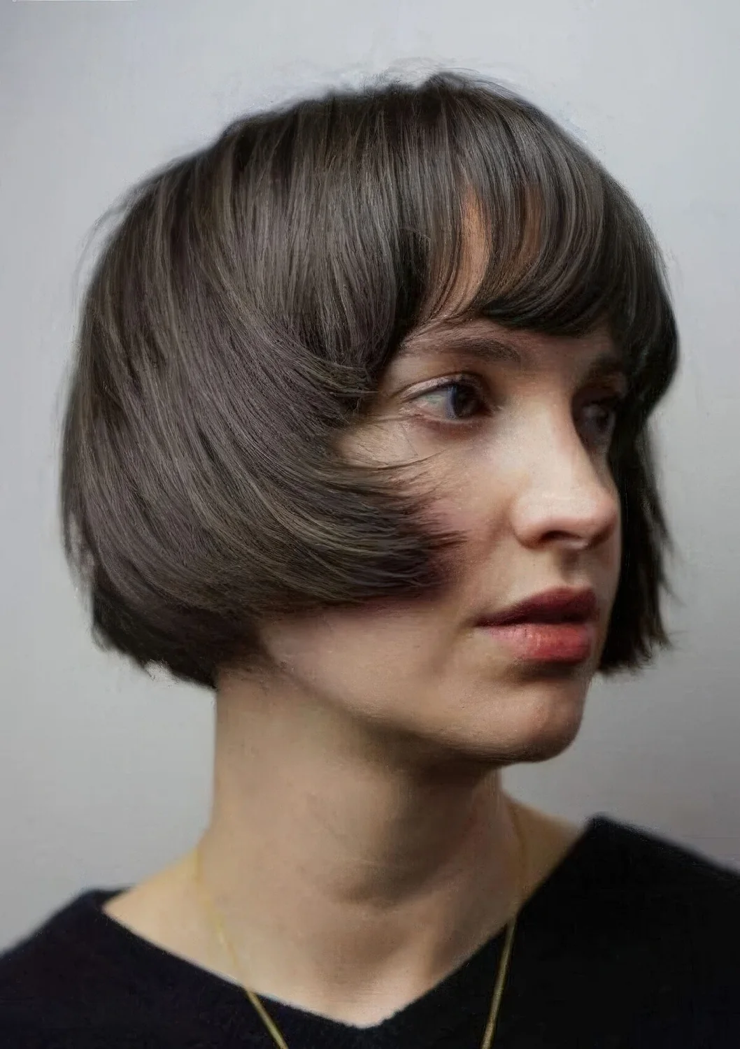 Brunette ear-length bob with a classic fringe and curved ends.