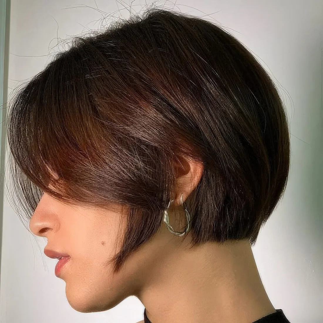 Brunette ear-length bob with side bangs.
