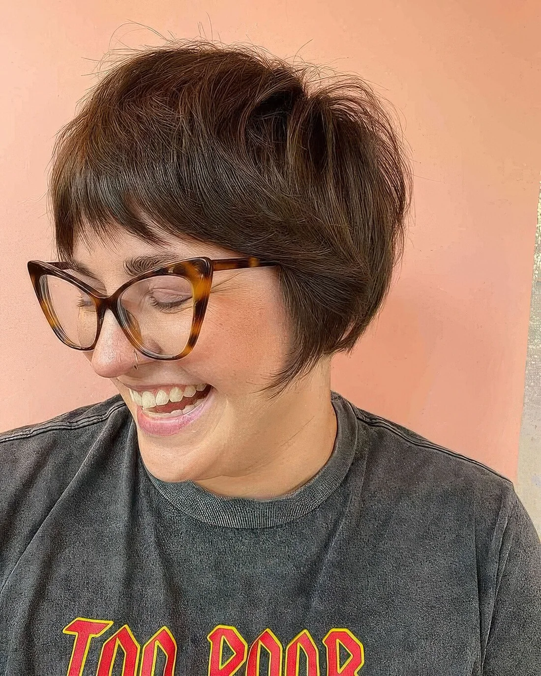 Brunette ear-length bob with wispy bangs and volume.